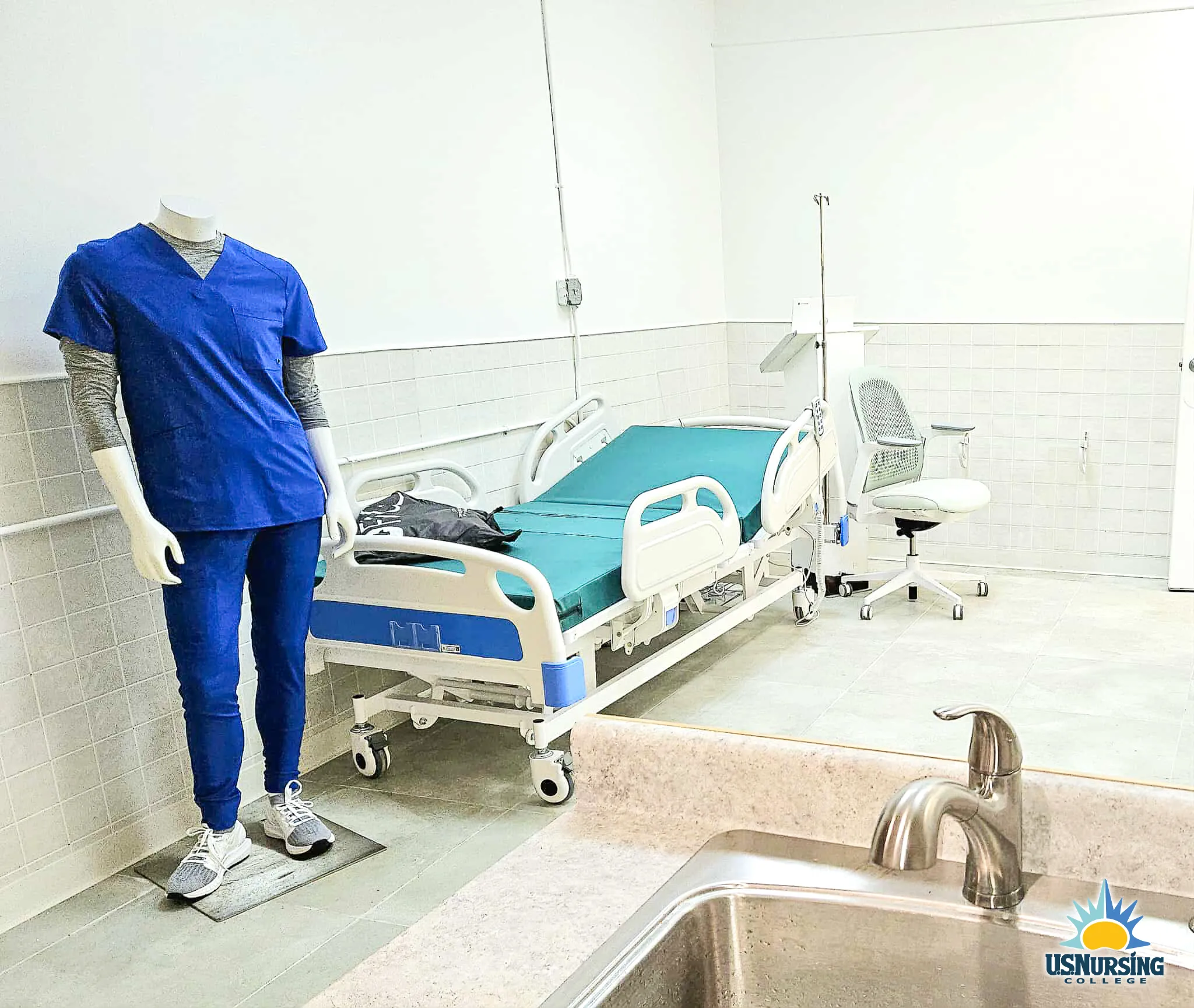 Nursing fundamentals simulation suite with hospital beds and scrub-clad manikin