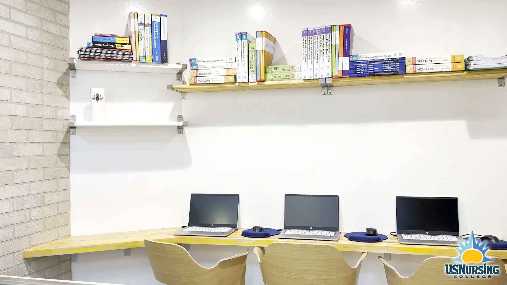 Computer learning stations with laptops and nursing reference books