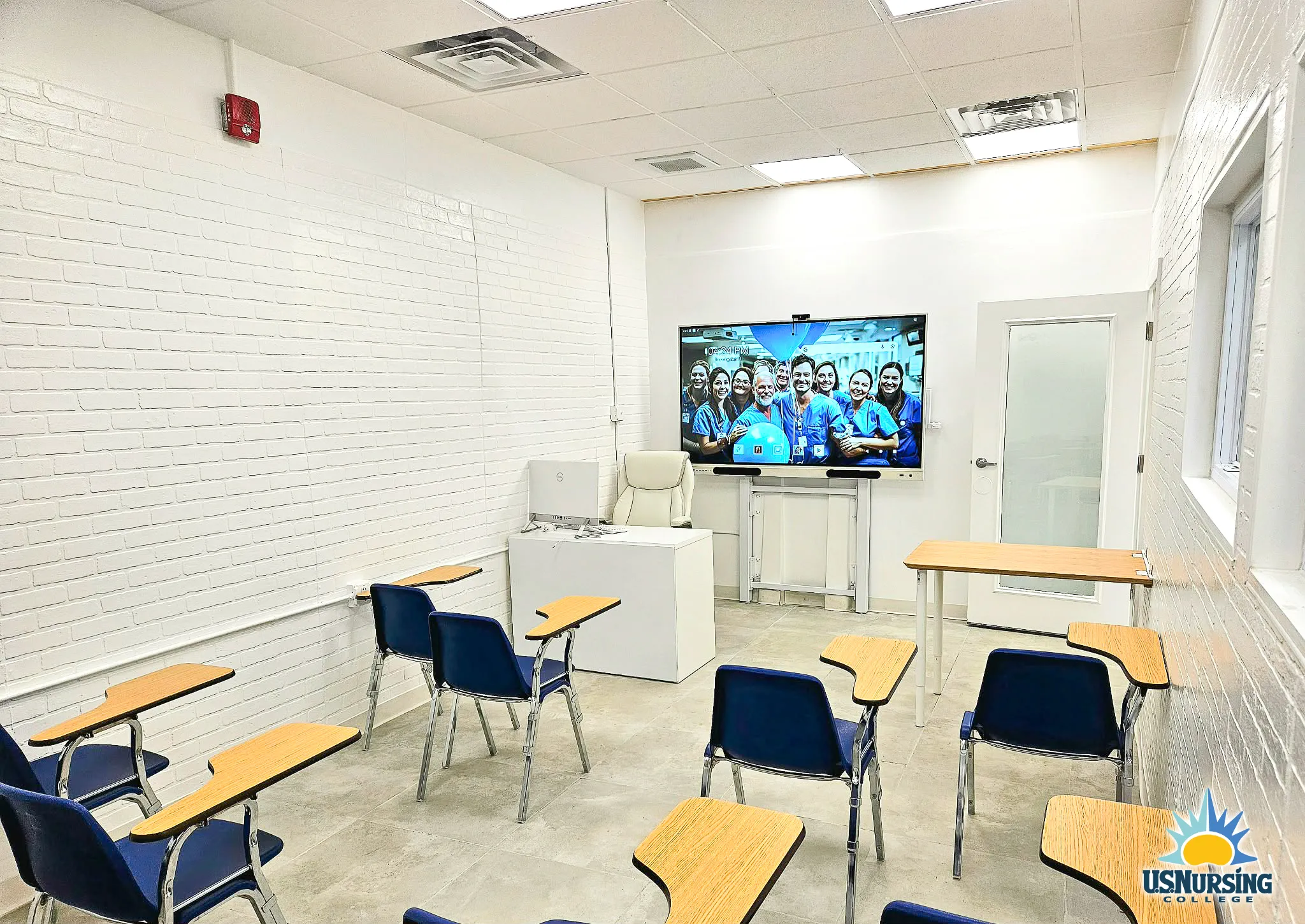 Lecture classroom with student desks and wall-mounted display